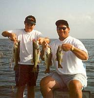 Two proud anglers showing-off their bass.